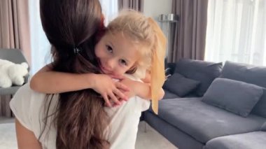 Küçük kız evde annesine duygusal olarak sarılıyor. Yüksek kalite 4k görüntü