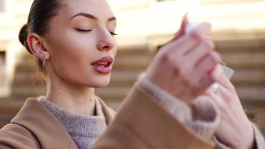 Prag, Avrupa şehir merkezindeki makyaj malzemelerini kontrol etmek için aynaya bakan genç bir kadın. Yüksek kalite 4k görüntü