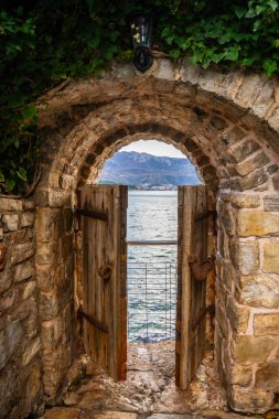 Karadağ 'ın deniz kıyısının sonunda küçük bir kapısı olan, kışın Budva' nın eski Budva kentindeki eski caddede insanlar yaşamaktadır. - Evet. Yüksek kalite fotoğraf
