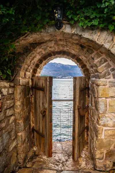 Karadağ 'ın deniz kıyısının sonunda küçük bir kapısı olan, kışın Budva' nın eski Budva kentindeki eski caddede insanlar yaşamaktadır. - Evet. Yüksek kalite fotoğraf