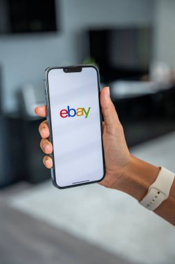 Prag, Çek Cumhuriyeti - 2 Mayıs 2024: Mobil uygulama uygulaması Ebay ekranında iPhone 'u elinde tutan kadın. Yüksek kalite fotoğraf