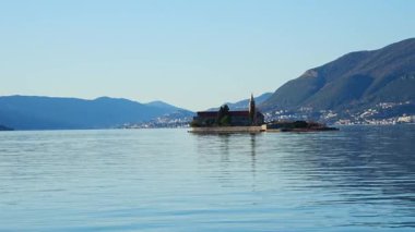 Karadağ 'ın Adriyatik Denizi' nin Kotor körfezindeki Tivat kenti yakınlarındaki bir yat teknesinden Merhamet Adası 'nın görüntüsü. Yüksek kalite 4k görüntü