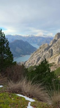 Kotor Körfezi Boca 'nın panoramik manzarası ve Karadağ' ın dağlık kesiminden kış mevsiminde dağlar. Yüksek kalite 4k görüntü