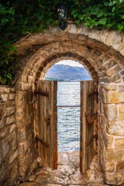 Karadağ 'ın deniz kıyısının sonunda küçük bir kapısı olan, kışın Budva' nın eski Budva kentindeki eski caddede insanlar yaşamaktadır. - Evet. Yüksek kalite fotoğraf