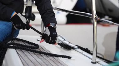 Genç yüzbaşı, Karadağ 'da kışın yapılan deniz yolculuğu sırasında bir yelkenliyi çalıştırıyor ve kontrol ediyor. Yüksek kalite 4k görüntü