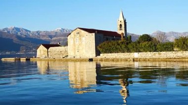 Karadağ 'ın Adriyatik Denizi' nin Kotor körfezindeki Tivat kenti yakınlarındaki bir yat teknesinden Merhamet Adası 'nın görüntüsü. Yüksek kalite 4k görüntü