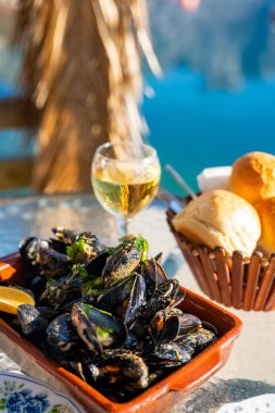 Karadağ 'ın Kotor Bay kentindeki istiridye çiftliğinde deniz manzaralı bir restoranda istiridye ve beyaz şarap. Yüksek kalite fotoğraf