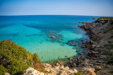Kumlu bir sahil şeridi ve Kuzey Kıbrıs 'ın en kuzeydoğusundaki buruna yakın kayalık kıyılar. Mavi bir gölün kristal berrak suları ve Akdeniz 'in dokunulmamış güzelliği. Yüksek kalite fotoğraf