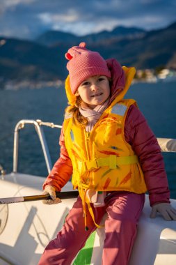 Karadağ 'ın Kotor Körfezi' nde eğitim sırasında, macera, özgürlük ve deniz sporlarını temsil eden bir yat kullanmayı öğrenen küçük bir kız. Yüksek kalite fotoğraf