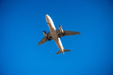 Gökyüzünde uçan bir uçağın alt görüntüsü, havacılık teknolojisi, uçuş rotası ve hava yolculuğu özgürlüğü. Yüksek kalite fotoğraf