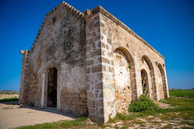 Kıbrıs 'ın kuzey kıyısındaki deniz kıyısında harabeler içindeki eski bir Ortodoks kilisesi duruyor. Bu görüntü tarihi, inancı ve Akdeniz kıyılarındaki zamanın geçişini yansıtıyor. Yüksek kalite fotoğraf