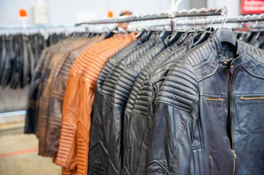 Deri motosiklet ceketleri düzgün bir şekilde sergileniyor, sert stili vurguluyor ve sürücüler için koruyucu teçhizat kullanıyor. Motosikletçi modası, dayanıklılık ve temel güvenlik giysisi kavramı. Yüksek kalite fotoğraf