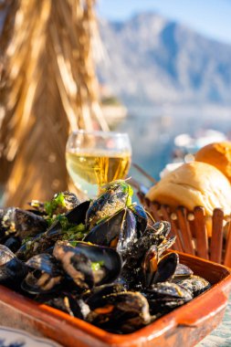 Karadağ 'ın Kotor Bay kentindeki istiridye çiftliğinde deniz manzaralı bir restoranda istiridye ve beyaz şarap. Yüksek kalite fotoğraf