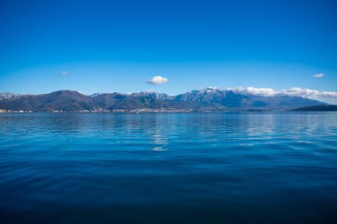 Karadağ 'ın Kotor Körfezi ve yüksek karlı dağların zirvesi, kıyılardaki küçük yerleşim yerleri ve Adriyatik Denizi' nin parlak mavi suları. Yüksek kalite fotoğraf