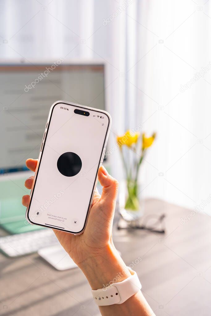 Prague, Czech republic - February 24, 2025: Back view of woman holding Iphone with Chat Gpt application on screen. Work assistant with Open Ai. Artificial Intelligence concept. High quality photo