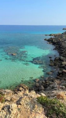 Kumlu bir sahil şeridi ve Kuzey Kıbrıs 'ın en kuzeydoğusundaki buruna yakın kayalık kıyılar. Mavi gölün berrak suları ve Akdeniz 'in el değmemiş güzelliği.. 