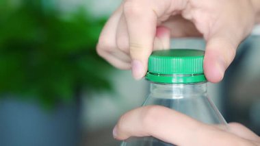 PET şişesinde durgun plastik kapak. Yeni tasarım, kapağın açıldıktan sonra şişeye bağlı kalması ve tüm paketin toplanıp geri dönüşümünün kolaylaştırılması anlamına geliyor. Yüksek kalite 4k görüntü