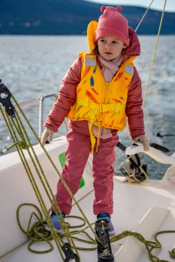 Karadağ 'ın Kotor Körfezi' nde eğitim sırasında, macera, özgürlük ve deniz sporlarını temsil eden bir yat kullanmayı öğrenen küçük bir kız. Yüksek kalite fotoğraf