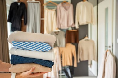 Giysi yığını yeniden satışa, bağışa ya da geri dönüşüme hazır kadın ellerinde. Sürdürülebilir moda seçimleri ikinci el kullanımı destekler, atıkları azaltır ve bilinçli tüketimi teşvik eder. Yüksek kalite fotoğraf