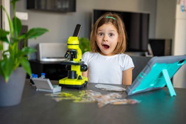 Çocuk bir şeyi ilk kez mikroskop altında gördükten sonra çok şaşırdı. Bilimsel keşif kavramı ve öğrenme sevinci. Yüksek kalite fotoğraf