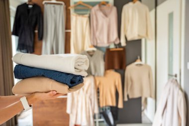 Giysi yığını yeniden satışa, bağışa ya da geri dönüşüme hazır kadın ellerinde. Sürdürülebilir moda seçimleri ikinci el kullanımı destekler, atıkları azaltır ve bilinçli tüketimi teşvik eder. Yüksek kalite fotoğraf