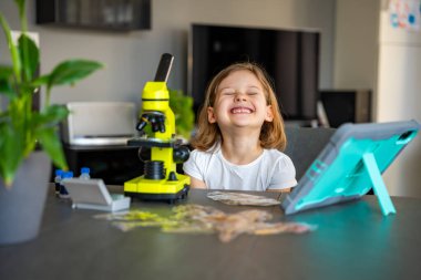 Çocuk bir şeyi ilk kez mikroskop altında gördükten sonra çok şaşırdı. Bilimsel keşif kavramı ve öğrenme sevinci. Yüksek kalite fotoğraf