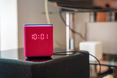 Moskova, Rusya - 21 Nisan 2025: Pembe Yandex Alice akıllı hoparlör arka planda bulanık diğer ev aletleri ile bir masada duruyor. Ses asistanı teknolojisi ve modern akıllı yaşam kavramı. 