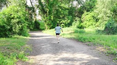 Yaz parkında genç bayan koşucu eğitimi. Spor salonundaki kadın dışarıda koşuyor. Sabah koşusu kavramı. Yüksek kalite 4k görüntü