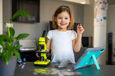 Küçük kız mikroskop altında soğan derisini inceliyor. Erken dönem bilim eğitimi ve hücre yapısı keşfi kavramı. Yüksek kalite fotoğraf