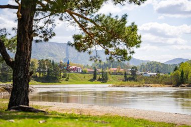 Biya Nehri 'nin üzerindeki Aşk Taşı' nın karşısındaki Turochak kasabasının manzarası. Huzur, bağlantı ve vahşi Rus doğasındaki kutsal yerler kavramı. Yüksek kalite fotoğraf