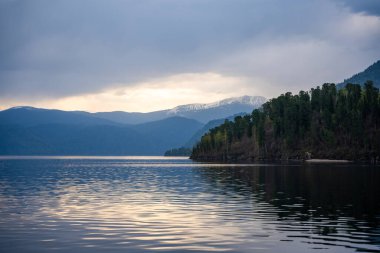 Sabahın erken saatlerinde Altai Rusya 'daki Teletskoye Gölü manzarası. Sakin su, yumuşak ışık ve Artybash yakınlarındaki sakin dağ atmosferi. Yüksek kalite fotoğraf