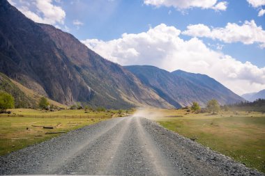 Chulyshman nehri boyunca uzanan toprak yol Altai Rusya Sahnesi 'ndeki Chulyshman Vadisi' nin girişinde vahşi dağ manzarası boyunca uzanır. Yüksek kalite fotoğraf