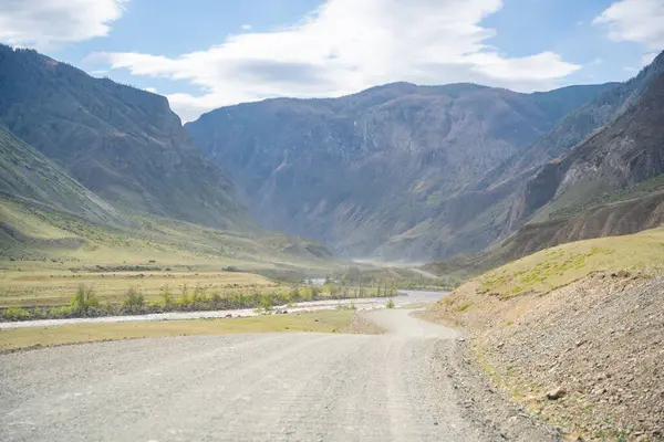 Dağ vadisi Altai Rusya 'daki Chulyshman nehri boyunca uzanan çakıl yolu manzaralı yabanda seyahat rotası. Yüksek kalite fotoğraf