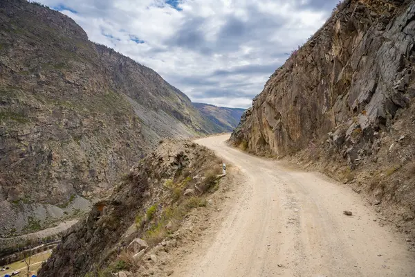 Altai dağlarındaki Katu Yaryk geçidinden geçen çakıl yolu uzak vadiyi yaylaya bağlıyor. Yüksek kalite fotoğraf