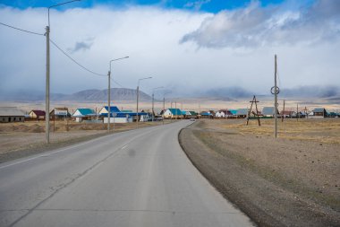 Kosh-Agach, Rusya - 8 Mayıs 2025: Kosh-Agach Altai Rusya 'da sokaklar, evler ve karayolu. Sibirya 'nın uzak bir dağ kasabasının kentsel manzarası