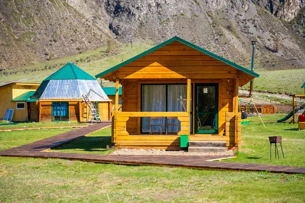 Aktash, Rusya - 9 Mayıs 2025: Aktash Altai Rusya yakınlarındaki Altai-Kabay 'da tahta turist kulübeleri. Sibirya doğasını keşfeden gezginler için manzaralı dağ manzaralı bir yerleşim yeri. Yüksek kalite fotoğraf