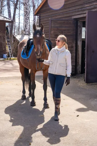 Çiftlikte atıyla poz veren genç bir kadın. Doğayla uyum içinde kadınlık ve güç kavramı. Yüksek kalite fotoğraf