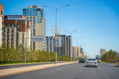 Astana, Kazakistan - 21 Mayıs 2025: Astana Kazakistan 'ın çağdaş binaları ve kentsel altyapısına sahip modern sokakları. Dinamik şehir ortamı mimari ilerlemeyi ve yaşam tarzını yansıtıyor. 