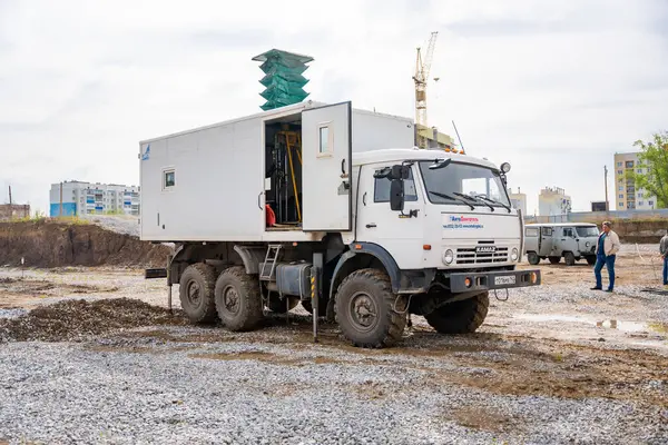 Belovo, Rusya - 18 Mayıs 2025: İnşaat alanında bir KamAZ kamyonuna yerleştirilen jeoteknik araştırmalar için mobil sondaj platformu. Toprak testi, yeraltı analizi ve temel planlaması.. 