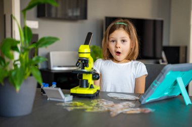 Çocuk bir şeyi ilk kez mikroskop altında gördükten sonra çok şaşırdı. Bilimsel keşif kavramı ve öğrenme sevinci. Yüksek kalite fotoğraf