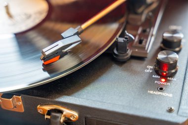 Plakçalar iğnesinin yakın plan görüntüsü, kayıt sırasında vinil kanalları takip ediyor. Analog ses detayı retro müzik atmosferini yakalıyor. Yüksek kalite fotoğraf