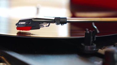 Plakçalar iğnesinin yakın plan görüntüsü, kayıt sırasında vinil kanalları takip ediyor. Analog ses detayı retro müzik atmosferini yakalıyor. Yüksek kalite 4k görüntü