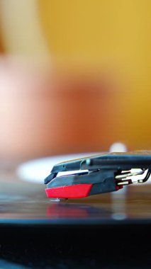 Plakçalar iğnesinin yakın plan görüntüsü, kayıt sırasında vinil kanalları takip ediyor. Analog ses detayı retro müzik atmosferini yakalıyor. Dikey video. Yüksek kalite 4k görüntü