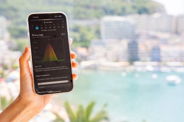 Budva, Karadağ - 12 Haziran 2025: Hava durumu uygulamasında UV endeksi gösteren iPhone ekranının yakın çekimi. Akıllı telefon arayüzünde gerçek zamanlı ultraviyole radyasyon seviyesi gösteriliyor. 