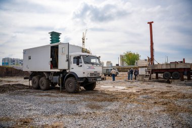Belovo, Rusya - 18 Mayıs 2025: İnşaat alanında bir KamAZ kamyonuna yerleştirilen jeoteknik araştırmalar için mobil sondaj platformu. Toprak testi, yeraltı analizi ve temel planlaması.. 