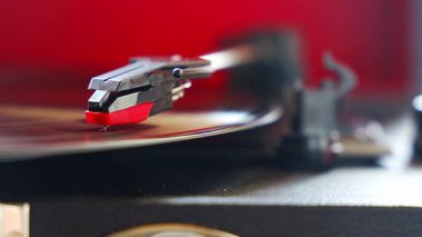 Plakçalar iğnesinin yakın plan görüntüsü, kayıt sırasında vinil kanalları takip ediyor. Analog ses detayı retro müzik atmosferini yakalıyor. Yüksek kalite 4k görüntü