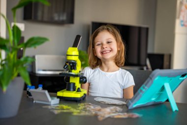 Çocuk bir şeyi ilk kez mikroskop altında gördükten sonra çok şaşırdı. Bilimsel keşif kavramı ve öğrenme sevinci. Yüksek kalite fotoğraf