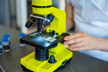 Mikroskop incelemesi için örnek hazırlayan küçük kızın ellerine yakından bakın. Bilimsel öğrenme ve merak güdümlü keşif kavramı. Yüksek kalite fotoğraf