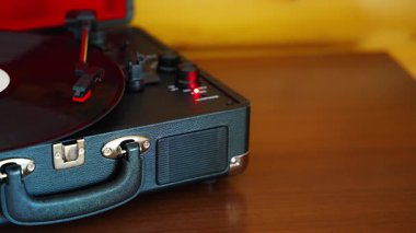 Klasik bavul tarzı plak çalar vinil plak çeviriyor. Retro müzik hareket halinde. İç mekanda nostaljik bir atmosfer yaratıyor. Yüksek kalite 4k görüntü