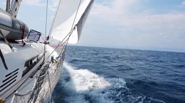 Denizi yarıp geçen bir yatın yanında Hırvatistan yakınlarında yelkenler açılıyor. Hareket, özgürlük, yelkencilik yaşam tarzı ve açık denizde macera. Yüksek kalite 4k görüntü